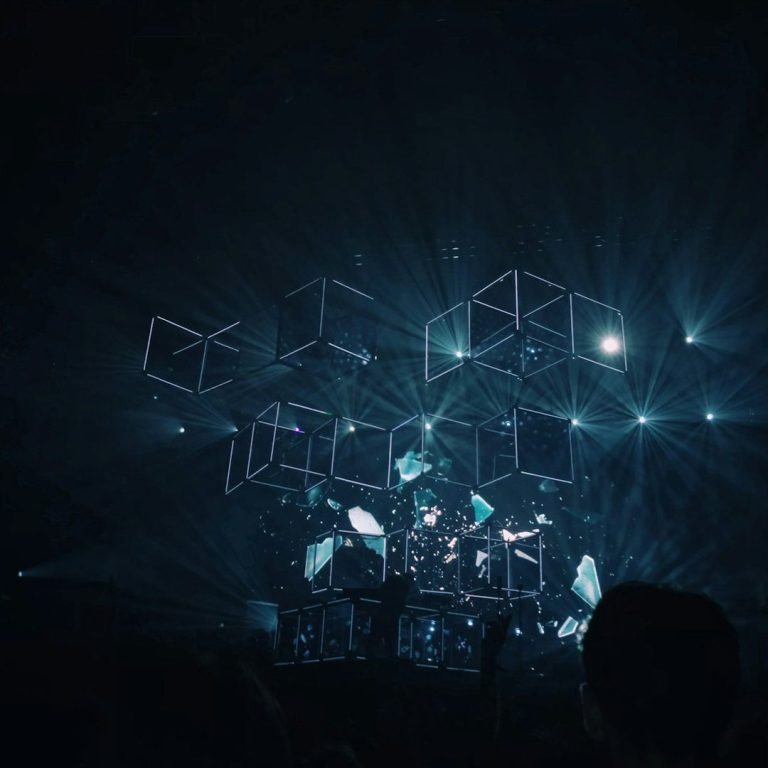 A dynamic light display with geometric shapes at a concert or event.