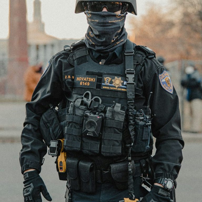 PITC Module 2 A police officer in tactical gear stands confidently, with equipment visibly secured.