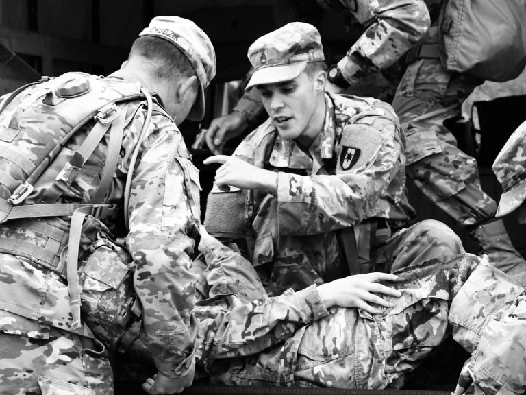 Soldiers assisting an injured comrade during a military operation.