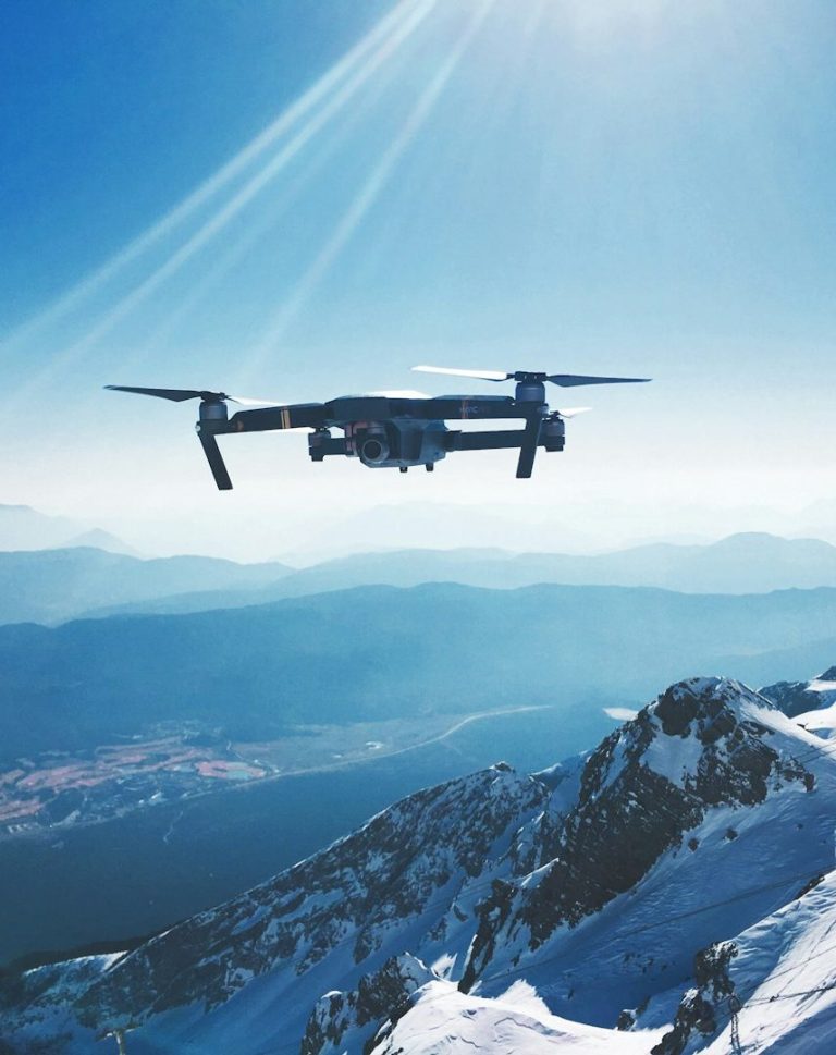 Two armed officers in tactical gear apprehend a restrained man in an indoor setting.